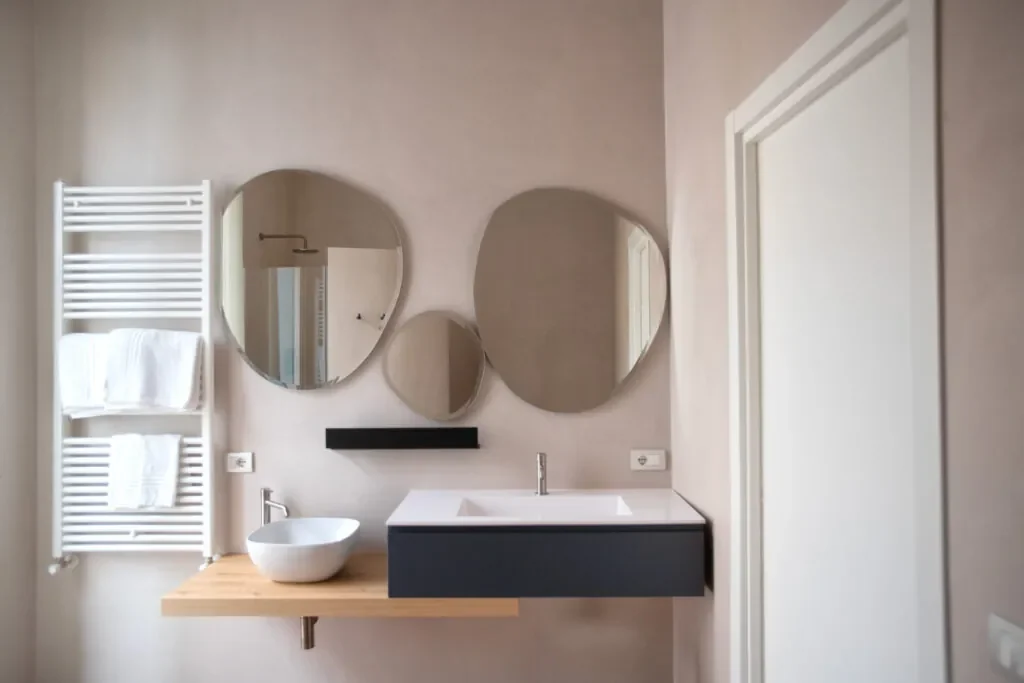 Due specchi tondi sopra il piano in legno del bagno