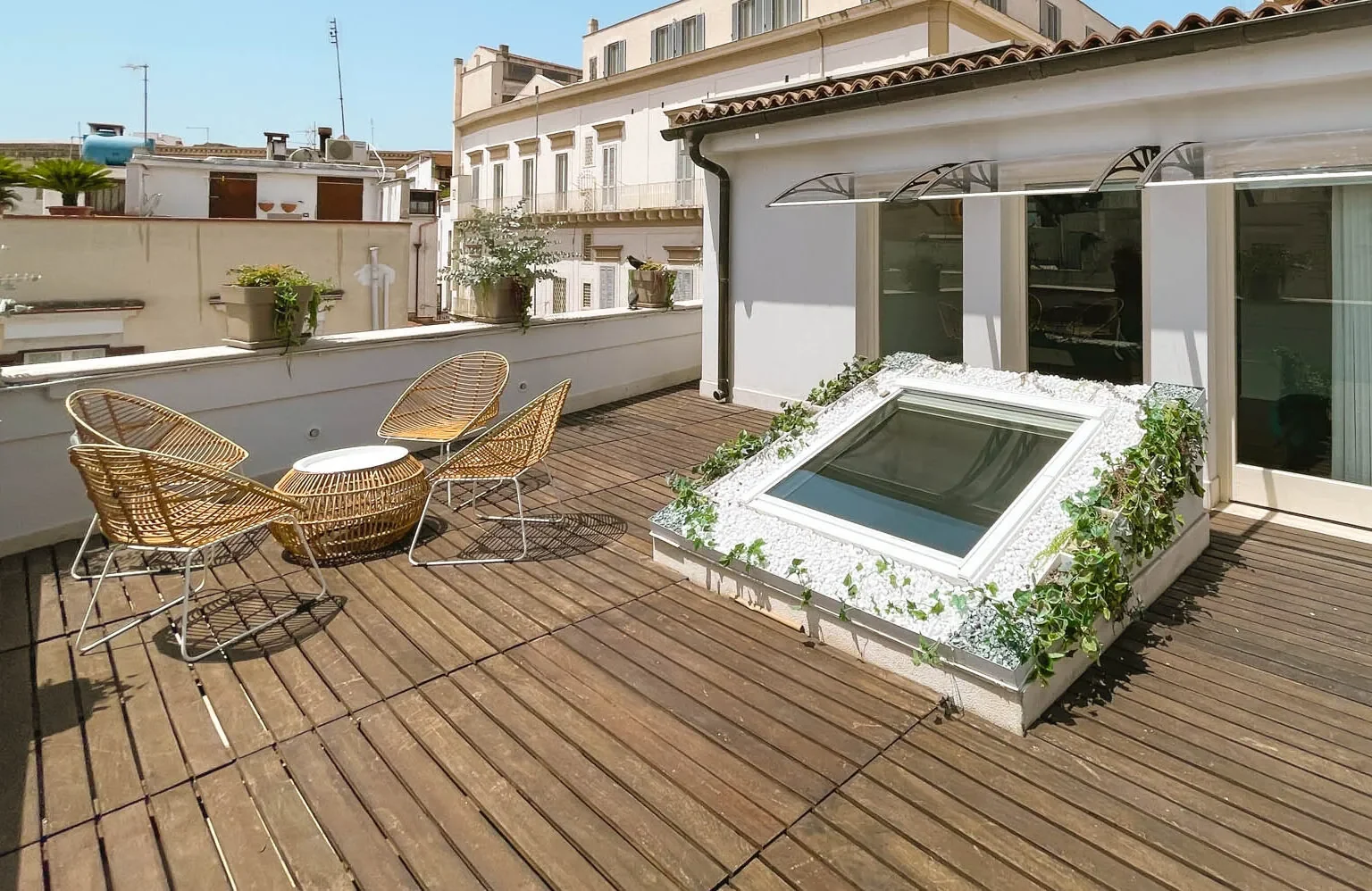 Terrazza privata di Fos con arredi in vimini e piante