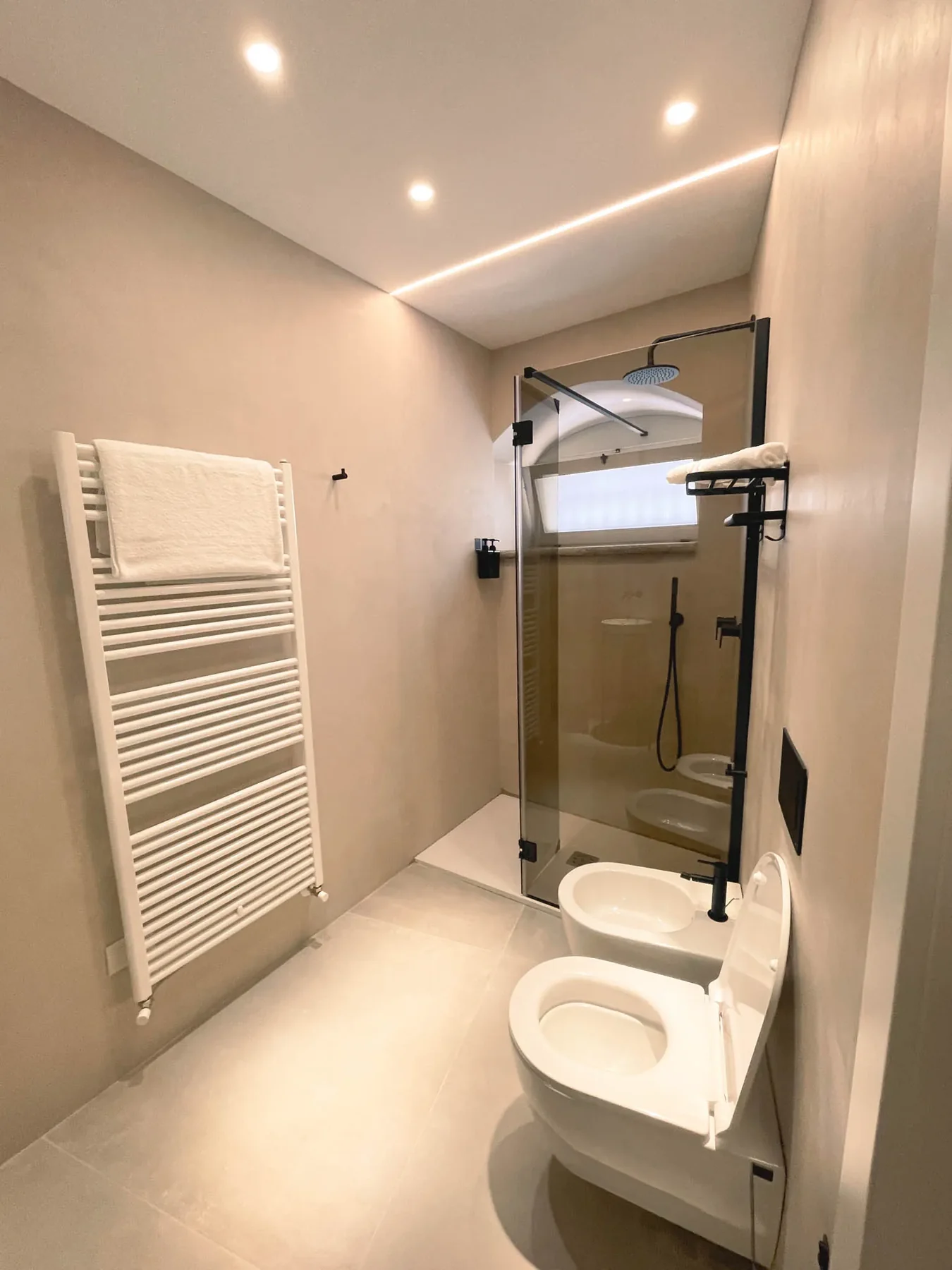 Box doccia in vetro di Pètra accanto al termoarredo
