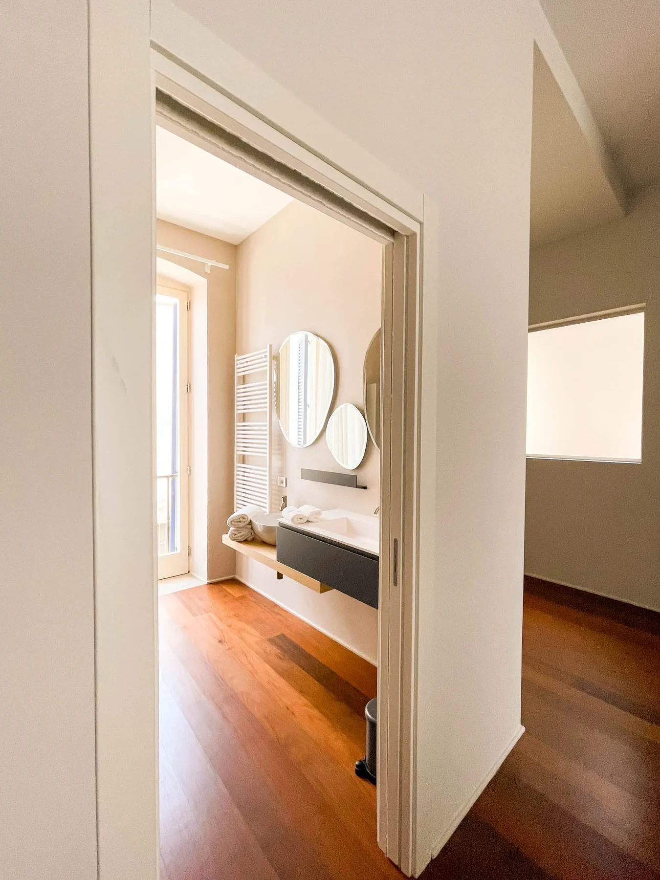 Letto e pavimento in legno di Xylo visti dal bagno