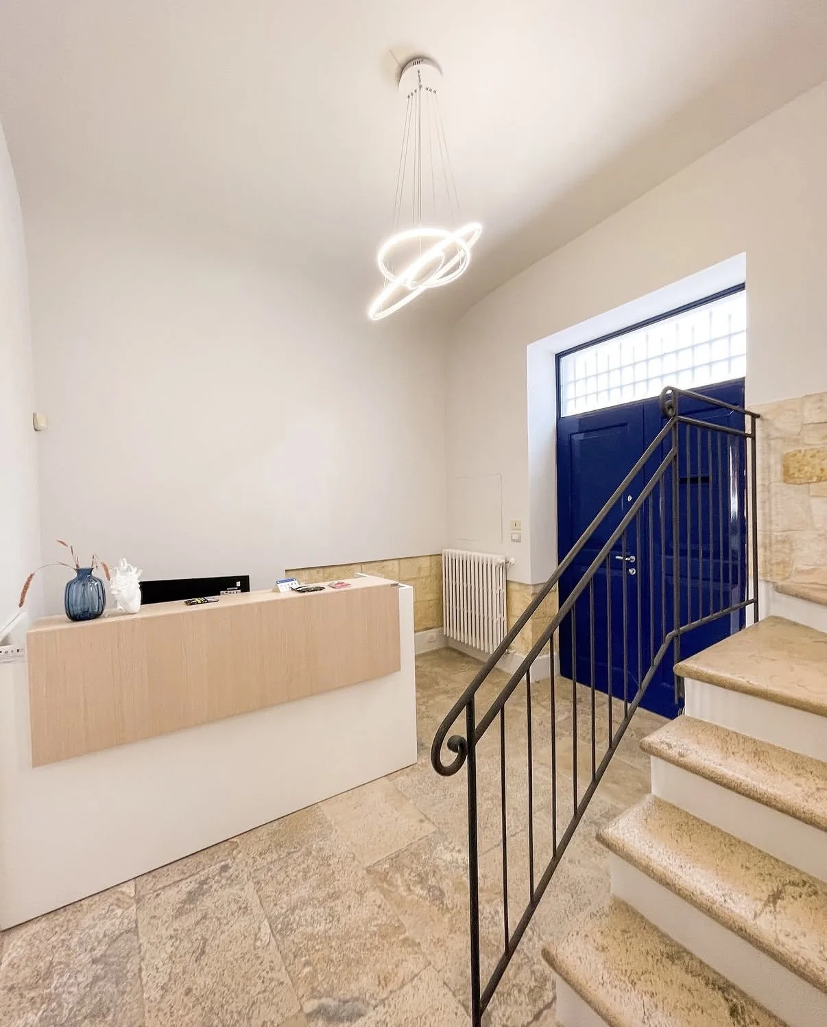 Reception con scala in pietra e portone blu