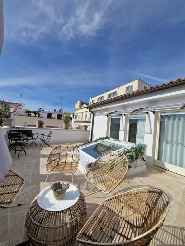 Terrazza con tavolo e sedie in vimini sui tetti di Andria